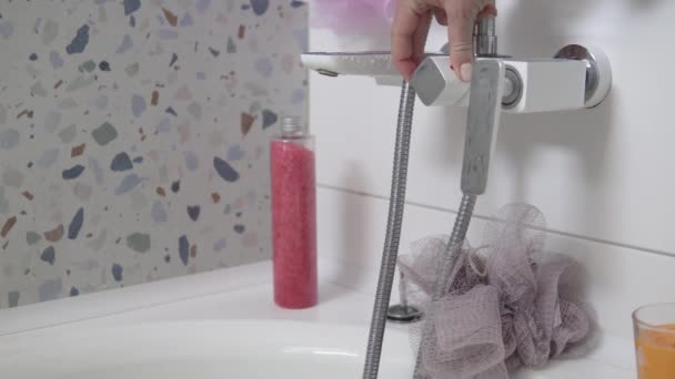 Kvinnors hand öppnar vattenblandaren i badrummet. — Stockvideo