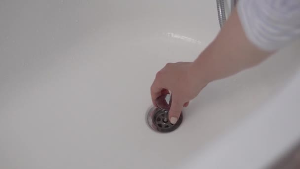 A mão das mulheres é coberta com uma caneca no banheiro e liga a água — Vídeo de Stock