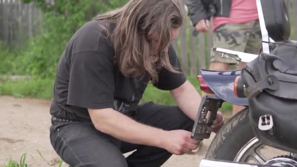 Der Mechaniker repariert das Motorrad im Sommer auf der Straße — Stockvideo