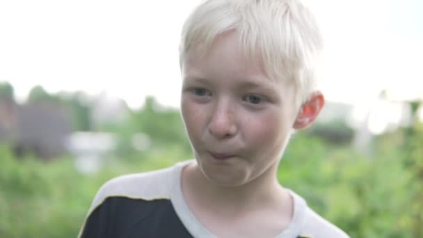 Close-up van het gezicht van een mooie blonde jongen zomer buiten — Stockvideo