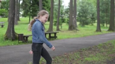 Yavaş çekim, güzel kız yazın yeşil bir parka gider.