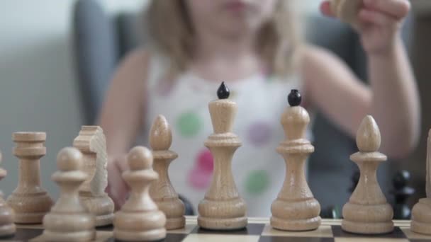 A close-up of the chessboard, the girl puts the pawns on the chessboard — Stock Video