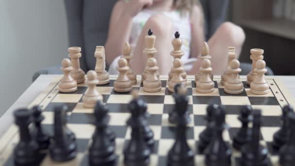 Malá holčička se učí hrát šachy doma se svým otcem — Stock video