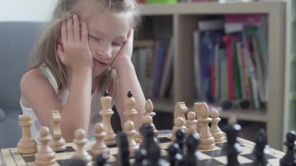Una ragazzina sta dormendo in una lezione di scacchi. primo piano — Video Stock