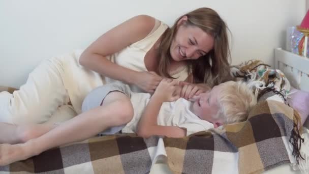 En mor leker med sin son hemma, en kvinna skadar ett skolbarn. — Stockvideo