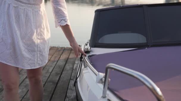 Una mano de mujer conduce a lo largo de la barandilla del yate en el verano al atardecer, — Vídeos de Stock