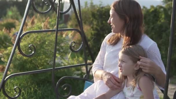 Söt mamma och dotter gunga på en gunga på sommaren i parken — Stockvideo