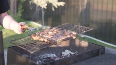 Bir adam yazın sokakta tavuk kebabı kızartıyor.