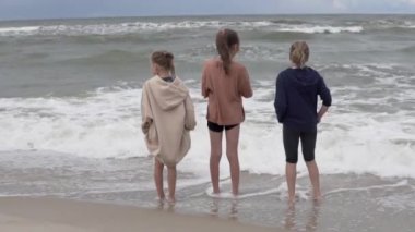 Yazın üç kız sahilden denize bakıyor..