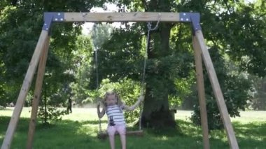 Bebek parktaki ahşap bir salıncakta yükseğe çıkar.