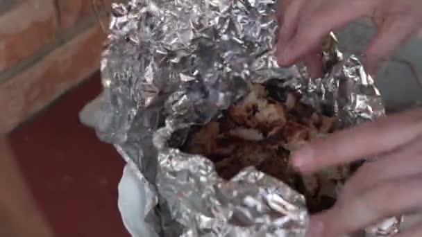 Gros plan, les mains des hommes emballent le kebab de poulet fini dans du papier d'aluminium dans le gazebo — Video