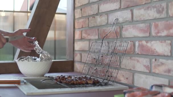 Muž vyndá hotový kebab z grilu do talíře v létě na venkově — Stock video