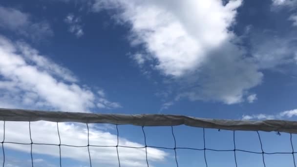 Strand röplabda hátterében egy gyönyörű felhős ég, — Stock videók