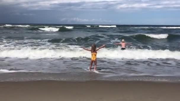 Les enfants se réjouissent dans les vagues et la tempête dans la mer — Video