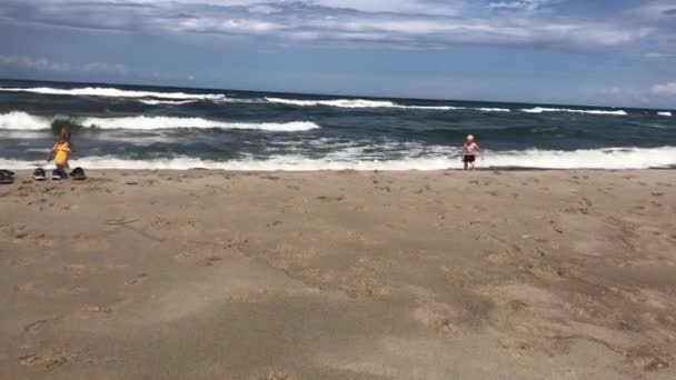 Les jeunes enfants seuls marchent le long de la plage au bord de la mer avec des vagues en été — Video