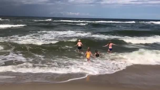 Anak-anak yang bahagia mandi di ombak di laut pada musim panas — Stok Video