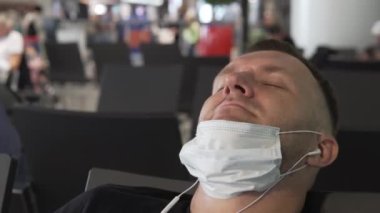 Yakın plan, burnundan aşağı tıbbi maske takan bir adam.,