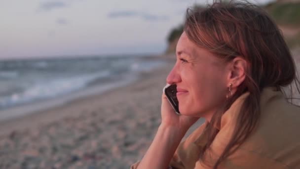 Gros plan, une femme qui parle au téléphone sur la plage — Video