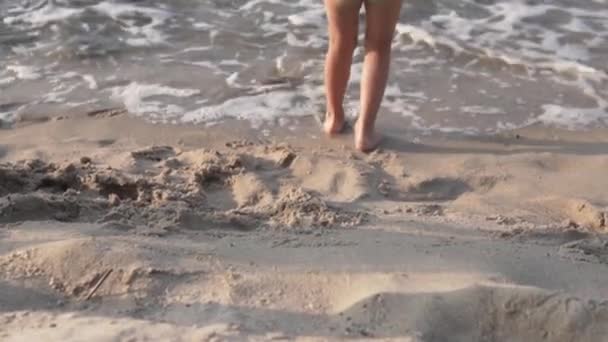Дети прогуливаются по песчаному пляжу у моря, крупным планом пешком — стоковое видео