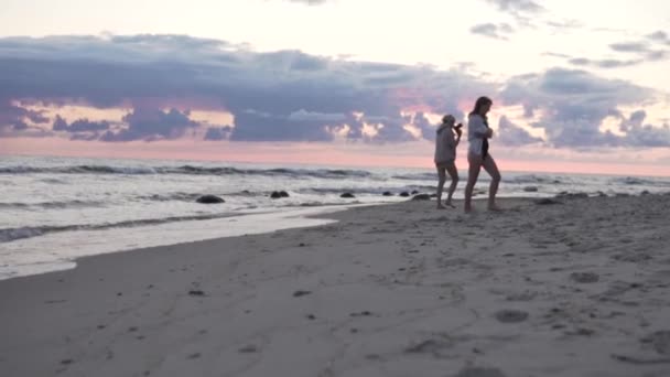 As meninas são fotografadas pelo mar no nascer do sol — Vídeo de Stock