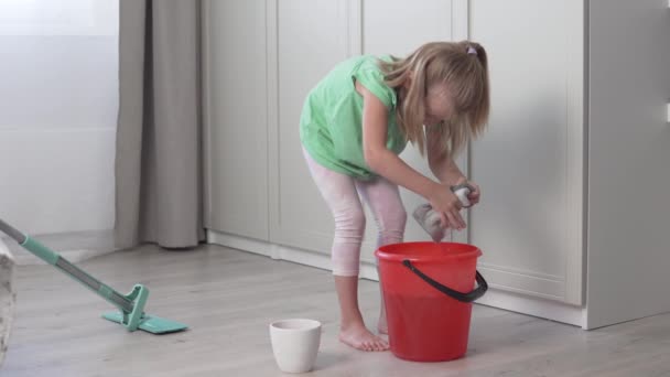 귀여운 작은 소녀가 아파트 청소를 한다. — 비디오