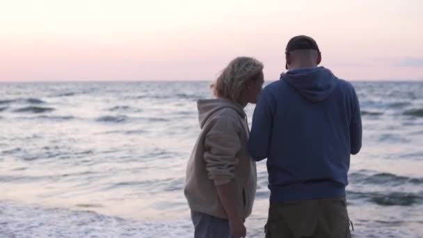 Kadın, kocasına akşam deniz kenarındaki telefonda nasıl fotoğraf çektireceğini anlatıyor.. — Stok video