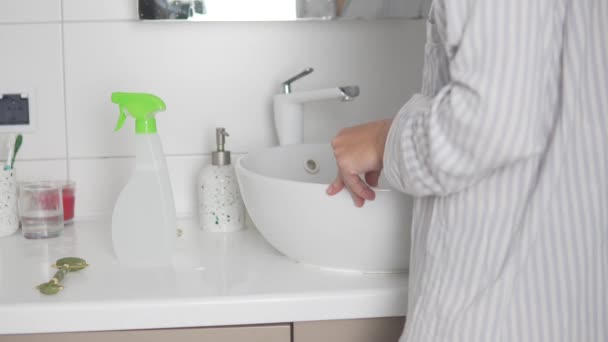 Una mujer lava un lavabo blanco en el baño con una esponja — Vídeos de Stock