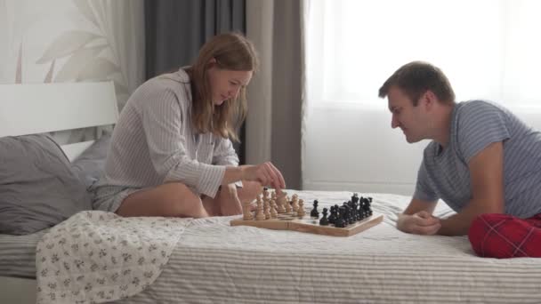 Karı koca sabahları evde yatakta satranç oynarlar. — Stok video