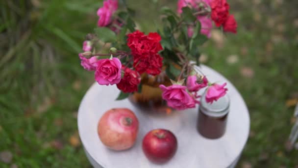 Een prachtig versierde tafel buiten in de herfst, een vaas van rode rozen en fruit op tafel in een café in de herfst in het park — Stockvideo