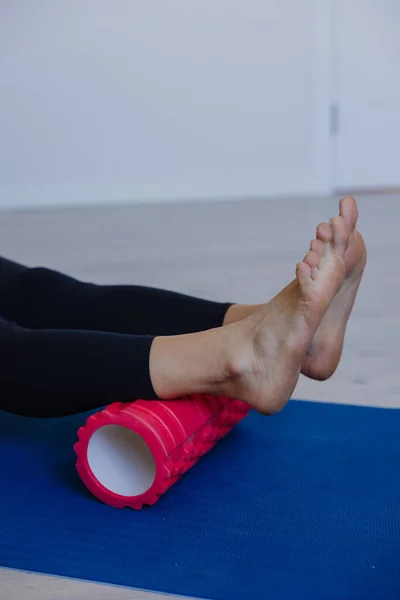 Ayaklar kırmızı köpüklü rulo üzerinde döner plantar masajı ve egzersizden sonra iyileşme, kendi kendine miyofasyal gevşeme