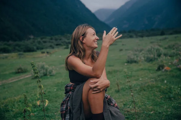 Beyaz bir kadın vadiyi işaret ediyor. Sohbet enerjisiyle anlamlı rehber rolü, çizmeler.
