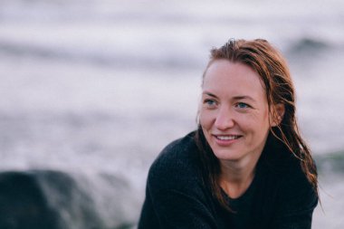 Close-up, the face of a beautiful happy woman against the background of the sea and dawn,