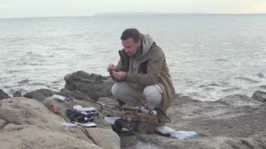 Adamın biri, İspanya 'nın Alicante şehrinde Cabo de las Huertas' ta kayalık bir sahilde olta takımı hazırlıyor. Sakin bir kış sahili sahili. Kıyı balıkçılığı, açık hava yaşam tarzı ve otantik Akdeniz kıyıları.