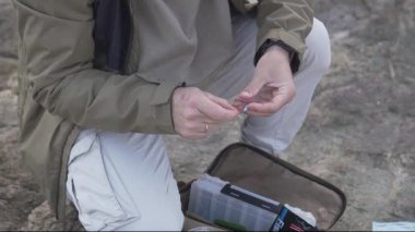 Denizde balık avlamaya hazırlanan bir balıkçının ellerinin yakın çekimi.,