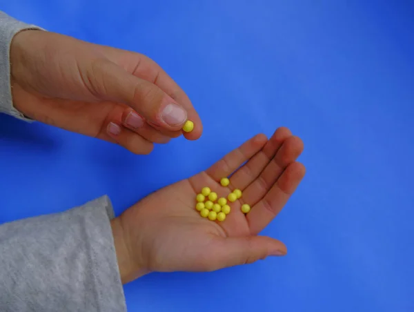 Άτομο Που Κρατά Κίτρινα Χάπια Στο Χέρι Γκρο Πλαν Μπλε — Φωτογραφία Αρχείου