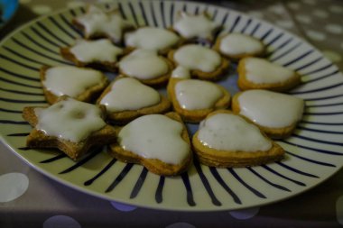 Farklı şekillerde zencefilli bisküviler ve yakın planda krema. Tatil günleri ev yapımı fırın