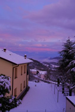Kışın gün batımında gökyüzünde dağ köyünde bir ev. Kış havası. Dağlarda tatil
