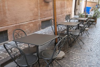 Boş metal masalar ve şehir caddesindeki açık kafenin sandalyeleri. Kentsel yaşam tarzı 