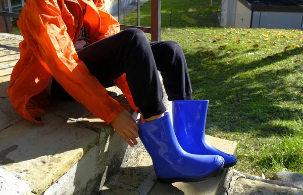 Kid Orange Raincoat Putting Blue Rubby Boots Sitting Stairs Backyard — Stock Photo, Image