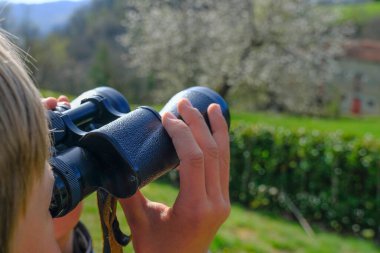 Çocuk dürbünle manzarayı izliyor. Eller dürbünü yakın çekimde tutuyor. Seyahat, turizm. Gelecek planlama kavramı 