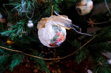 Noel ağacında asılı kumaş fiyonklu beyaz vintage top diğer dekorasyonlara yakın çekim. Ağaçta Noel süsü. Tatil dekorasyonu.