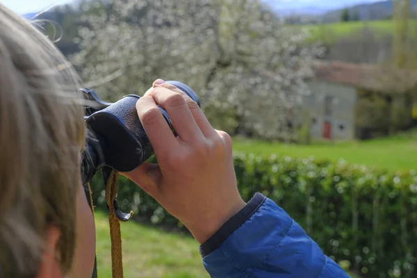 Çocuk dürbünle manzarayı izliyor. Eller dürbünü yakın çekimde tutuyor. Seyahat, turizm. Gelecek planlama kavramı