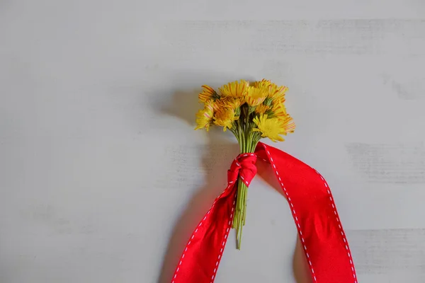 Букет Желтых Полевых Цветов Покрытых Красной Лентой Белом Деревянном Фоне — стоковое фото