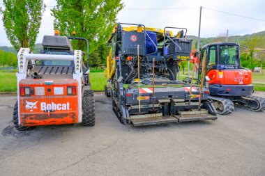 Haziran 2021 Parma, İtalya: Şehirde yol yapımına hazır farklı ağır yol makineleri park edildi. Excavator, asfalt kaldırıcı