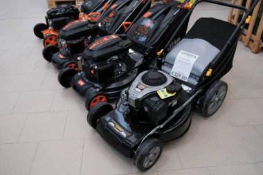 Temmuz 2021 Milan, İtalya: Mağazanın zemininde üç adet siyah ve turuncu çim biçme makinesi bulunuyor. Virium, Sikurotech logo çim biçme makinesi 