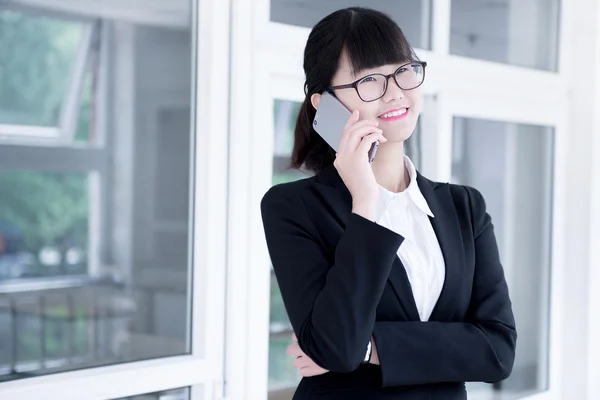 Современная деловая женщина в офисе, разговаривает по телефону — стоковое фото