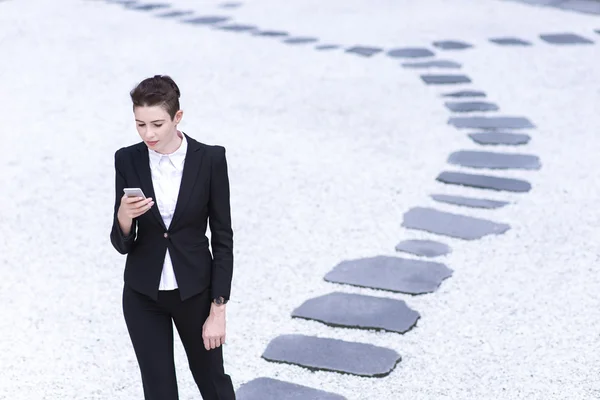 Современная деловая женщина играет на смартфоне — стоковое фото