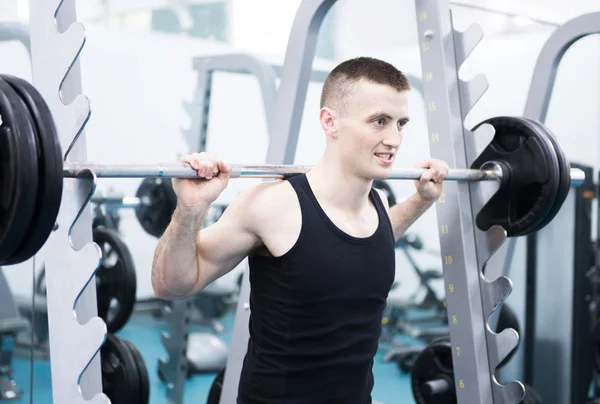 Hombre atlético con mancuernas en el gimnasio —  Fotos de Stock