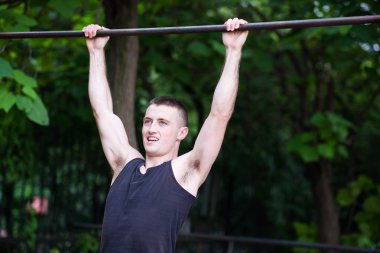 bir çubuğu açık pull-up yapan güçlü erkek