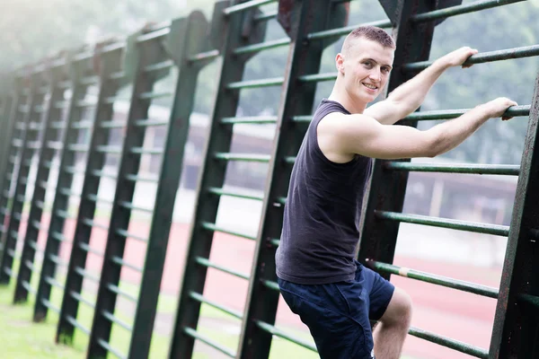 Athlete man climing a bar — Stock Photo, Image